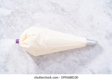 White Buttercream Frosting In A Piping Bag With A Metal Tip.