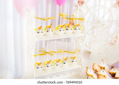 white cakes in the form of unicorns are located on a stand on two floors