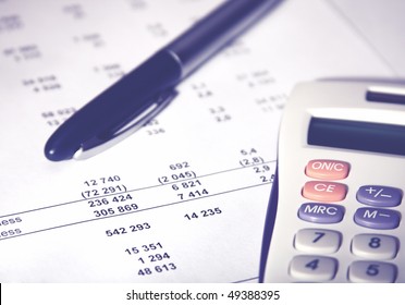White calculator and a blue pen lying on a financial report - Shutterstock ID 49388395