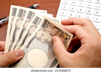 White calculator. Japanese banknotes. 10,000 yen bill. Concepts about money. - Shutterstock ID 2172440073
