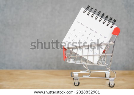 white calendar in shopping cart on wood and grunge grey background, sale ,flash sale and promotion, black Friday, advertising concept