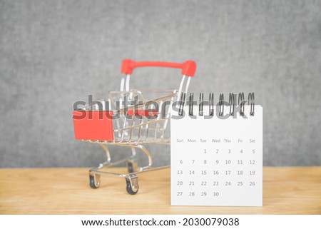 white calendar and shopping cart, in soft focus, on wood and grunge grey background, sale ,flash sale and promotion, black Friday, advertising concept