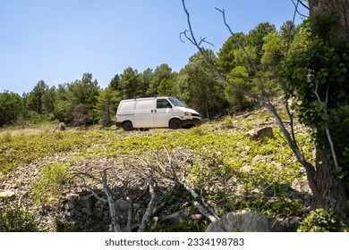 A white, camper van, parked in nature during the summer season. - Powered by Shutterstock