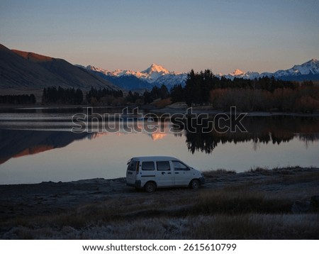 White campervan camping motorhome car with Mount D'Archiac idyllic remote rural countryside golden hour winter sunrise at Lake Camp, Southern Alps mountain landscape at Ashburton Lakes New Zealand