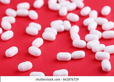 White candies gum on red background