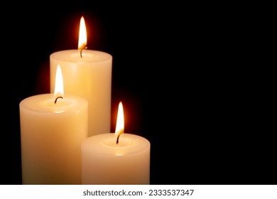 White candles with different size burning on black background. Copy space for text. - Powered by Shutterstock