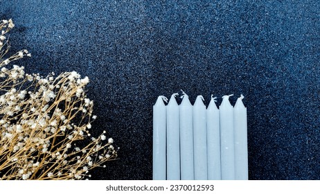 White candles on a black background with dried flowers. Copy space. - Shutterstock ID 2370012593