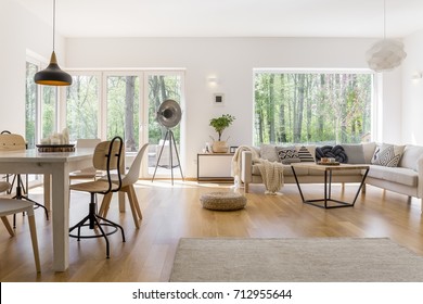 White Candles On Black Plate On Dining Table With Designed Chairs In Multifunctional Living Room