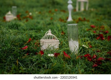 White Candlestick On The Grass Covered With Rose Petals