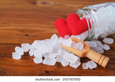 White Candy Rock Sugar, Crystal Sugar In Wooden Scoop And Glass Jar With Red Hearts On Wooden Background. Selected Focus. 