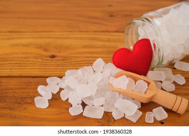 White Candy Rock Sugar, Crystal Sugar In Wooden Scoop And Glass Jar With Red Heart On Wooden Background. Selected Focus. 