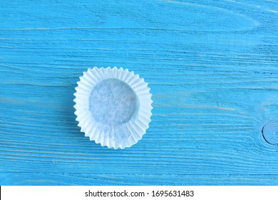 White candy wrappers. Truffles wrapping on blue wooden background. Paper Package for hand made chocolate candy. 
