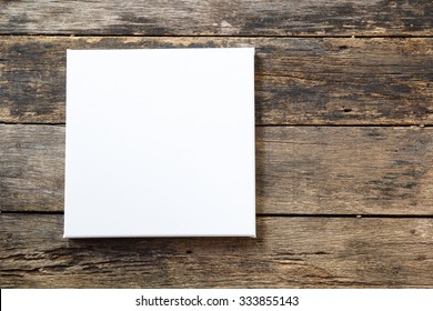 White Canvas Frame On A Wooden Background.