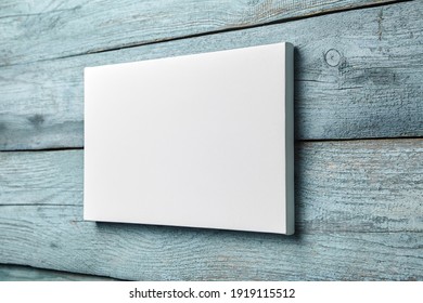 White Canvas Hanging On Light Blue Wooden Wall. Mockup, Wall Decor, Blank Canvas Stretched On Stretcher Bar, Side View