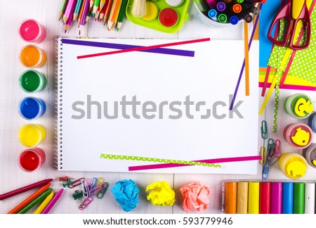 White canvas on a drawing table with lots of stationery objects making a center copy space for you text