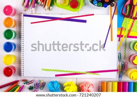 White canvas on a drawing table with lots of stationery objects making a center copy space for you text