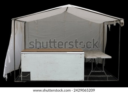 White canvas tent with  refrigerator on the street.  Isolated on black