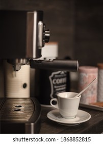 White Cappuccino Cup With Saucer On Kitchen Table With Modern Coffee Machine. Modern Coffee Station At Home