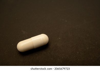 white capsule for patient on black paper. Prescription opioid oval pills. Opioid crisis. Medical white capsules isolated on a black background. Capsules for treatment