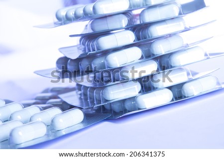 White capsules medicine in package under blue light