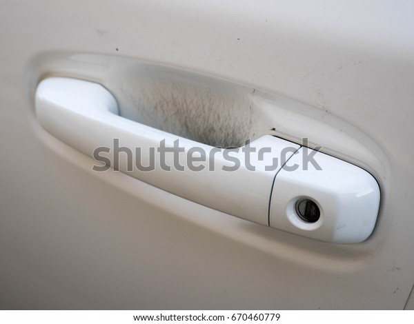 White\
car and automobile door handle with nail\
scratches