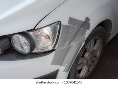 A White Car Bumper Damage Fixed By Duct Tape