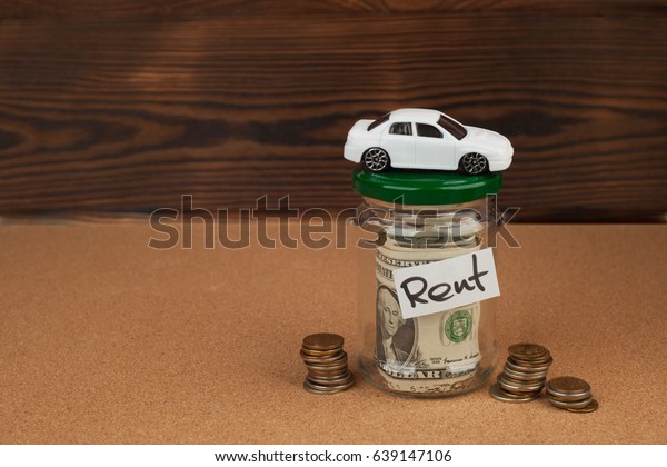 A white car with coins money and\
dollars  in the piggy bank, concept of capital\
accumulation