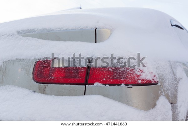 White car covered\
with snow during a\
blizzard