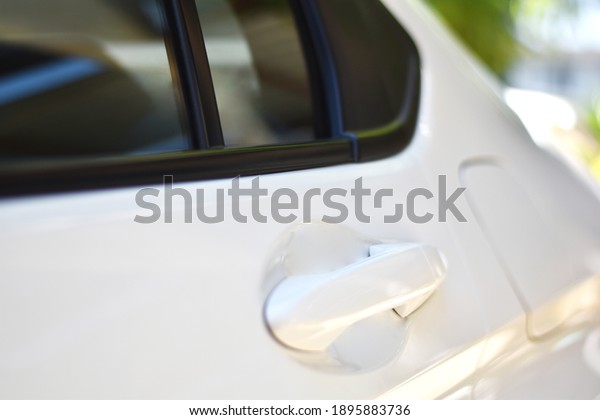 white car\
door handle with blurred glasses, back\
door