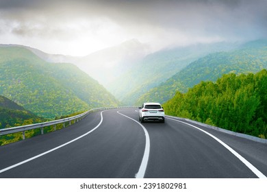 white car drive on mountain road landscape in winter. Nature scenery on highway in green mountains. Winter travel on black asphalt road. Car driving in the beautiful nature of Europe. Bavaria, Germany