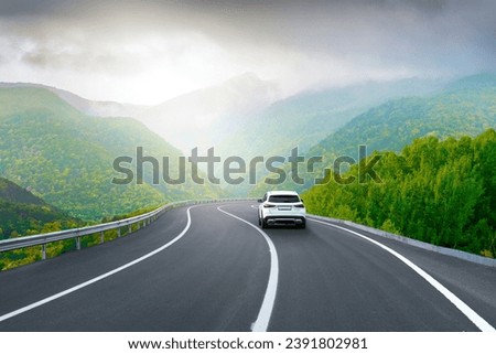 white car drive on mountain road landscape in winter. Nature scenery on highway in green mountains. Winter travel on black asphalt road. Car driving in the beautiful nature of Europe. Bavaria, Germany