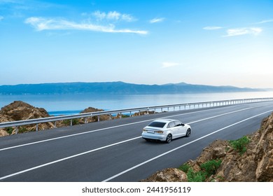 White car driving on the coastal road. road landscape in summer. it's nice to drive on beach side highway. Highway view on the coast on the way to summer vacation. Spain trip on beautiful travel road - Powered by Shutterstock