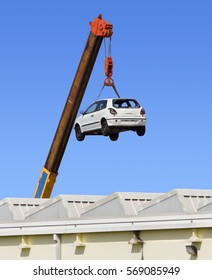 White Car Hanging By The Arm Of A Crane