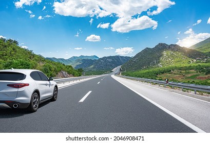 White car on a scenic road. Car on the road surrounded by a magnificent natural landscape. - Shutterstock ID 2046908471