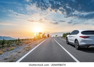 White car on a scenic road. Car on the road surrounded by a magnificent natural landscape.