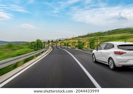 White car on a scenic road. Car on the road surrounded by a magnificent natural landscape.