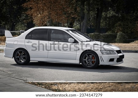White car on a street background. Modern city sport car with a spoiler wallpaper