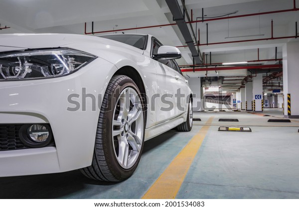 A white car\
parked in an underground car\
park