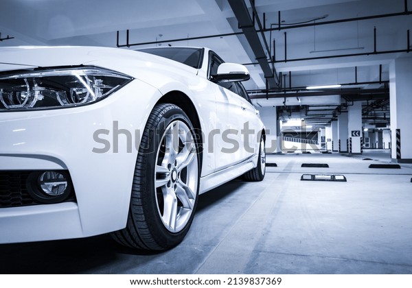 A white car\
parked in an underground car\
park