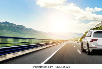 White car rushing along a high-speed highway. Toned photo. - Shutterstock ID 1130185526