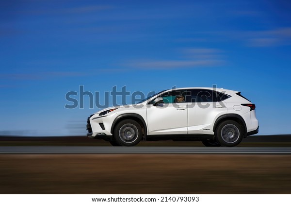 White car rushing along a high-speed\
highway. Toned photo. 27-03-2022 Riga,\
Latvia