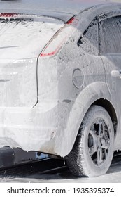 White Car In Soap Foam On The Car Wash