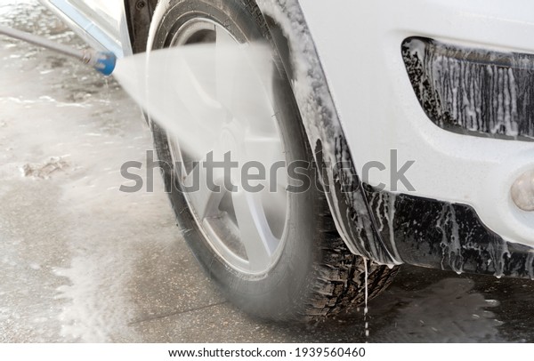 white car in soap foam\
on the car wash
