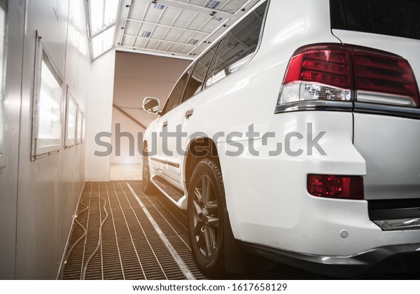 white car\
in a spray booth at shallow depth of\
field