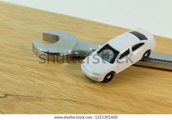 The white\
car toy on wood table  image close\
up.