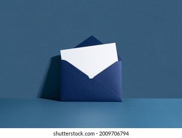 White card in a dark blue seal leaning against a blue wall. Invitation mockup, long shadow. - Shutterstock ID 2009706794