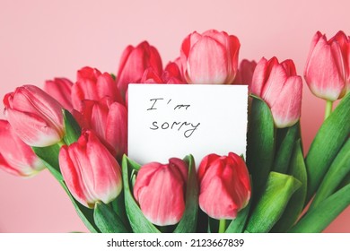 white card with the inscription i am sorry in a bouquet of beautiful tulips, the concept of apologies. - Shutterstock ID 2123667839