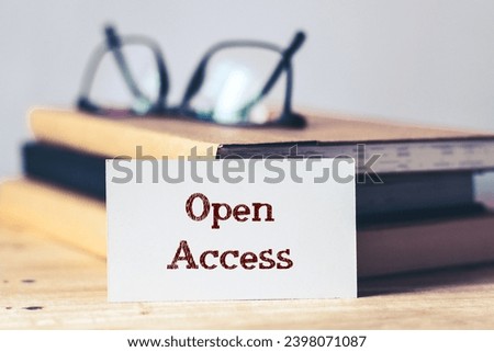 White card with the note Open Access on desk. Selective focus, open online access of academic information and research publications.