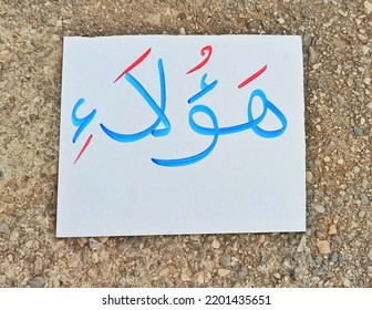 A White Card With The Words _these _ Written On It, In Arabic In Blue And The Diacritics In Red.