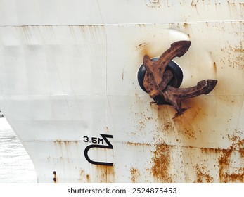 White cargo ship's with old anchor was alongside in port being pulled. While docked at the pier by large ropes on the sea port, with mountains, Island, blue sky background and transportation concept - Powered by Shutterstock